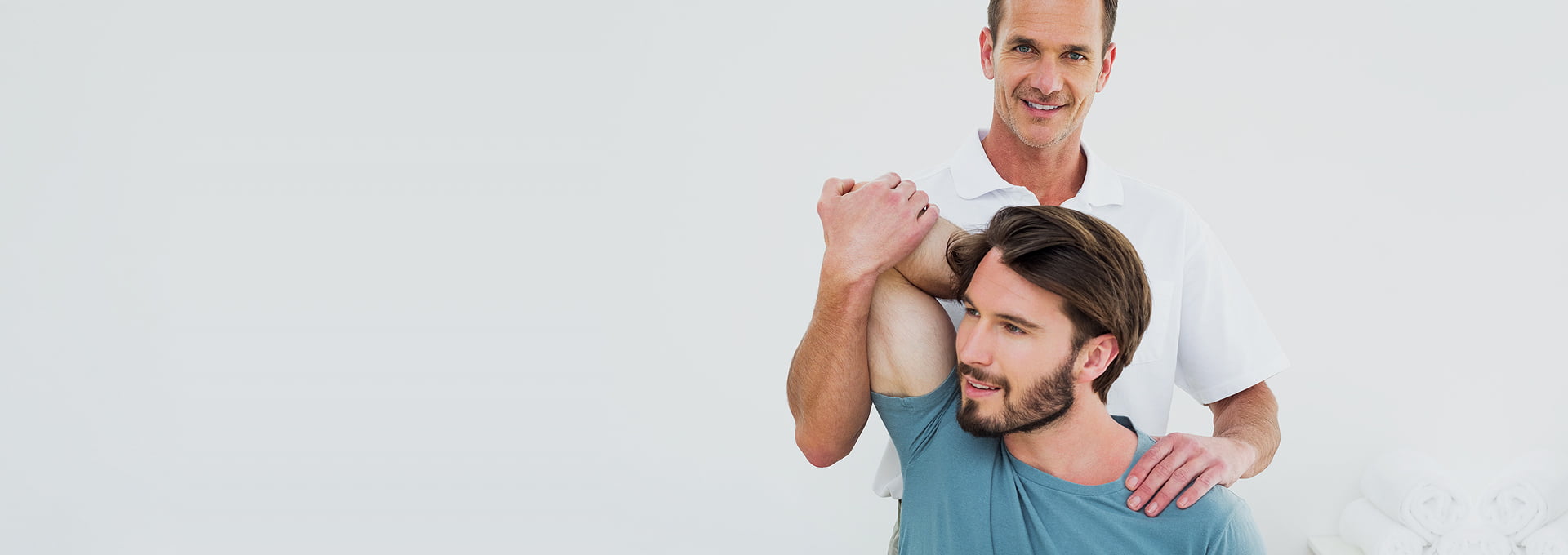 Two men are hugging and smiling for the camera.