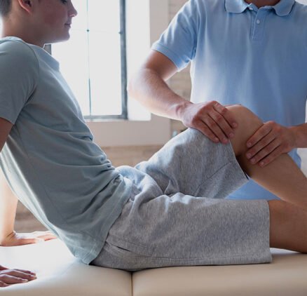 A man is getting his leg examined by an osteopath.