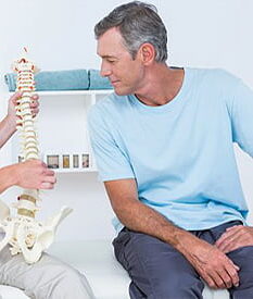 A man sitting down with his back bone in the middle of his body.